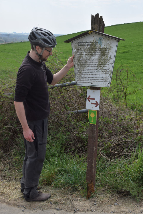 Abgefaulter Pfosten mit verdrecktem Schild